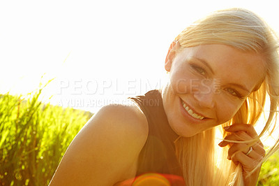 Buy stock photo A beautiful young blonde woman sitting in a field