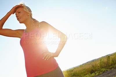 Buy stock photo A young woman in sporstwear relaxing after a jog