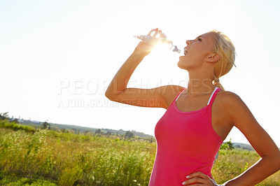 Buy stock photo A beautiful young woman in sportswear drinking water from a bottle