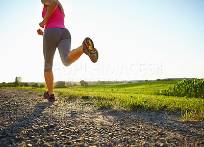 Buy stock photo Cropped shot of a young woman running along a dirt road