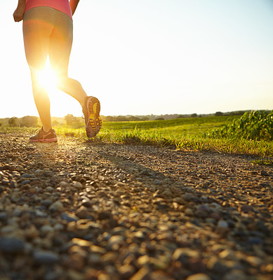 Buy stock photo Cropped shot of a young woman running along a dirt road