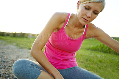 Buy stock photo A beautiful young woman sitting in a field before a jog