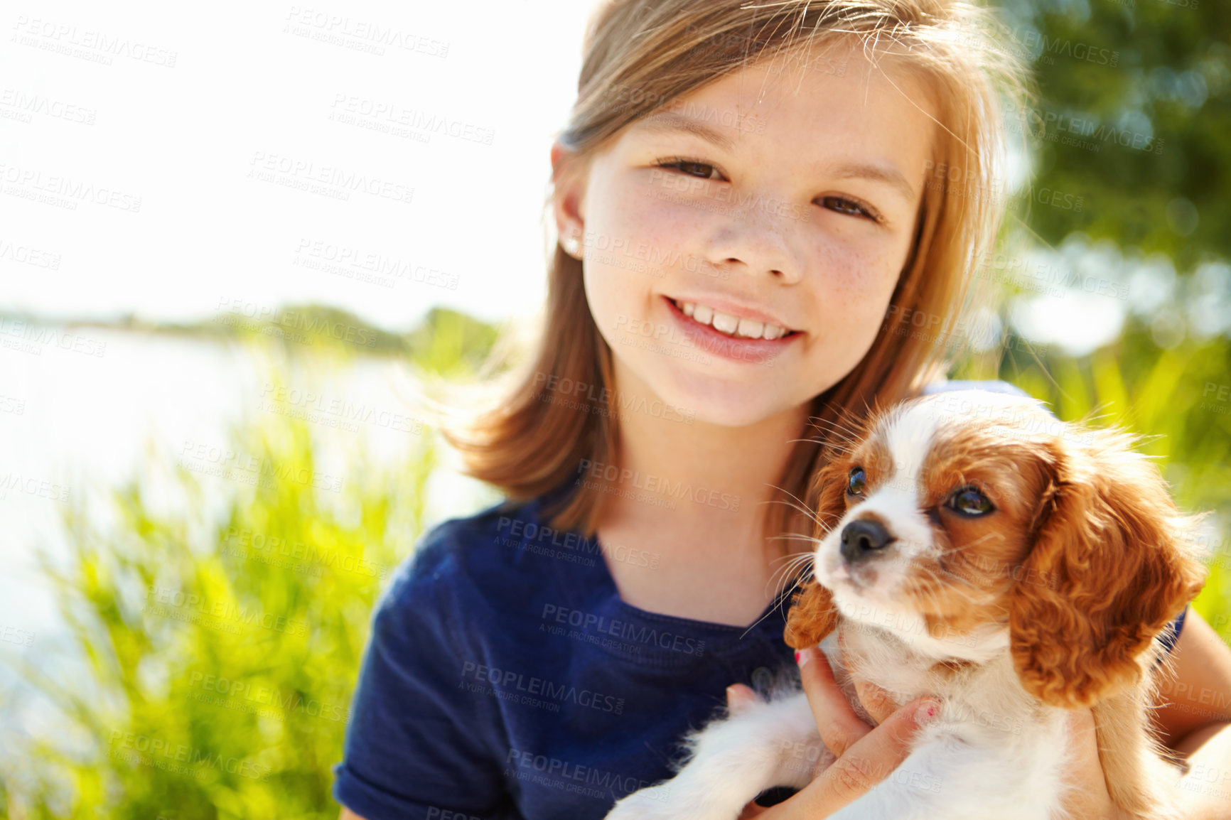 Buy stock photo Happy, nature and portrait of kid with dog for bonding, connection and loyalty with adoption. Sweet, animal and young girl playing with cavalier puppy for pet in childhood outdoor in park together.