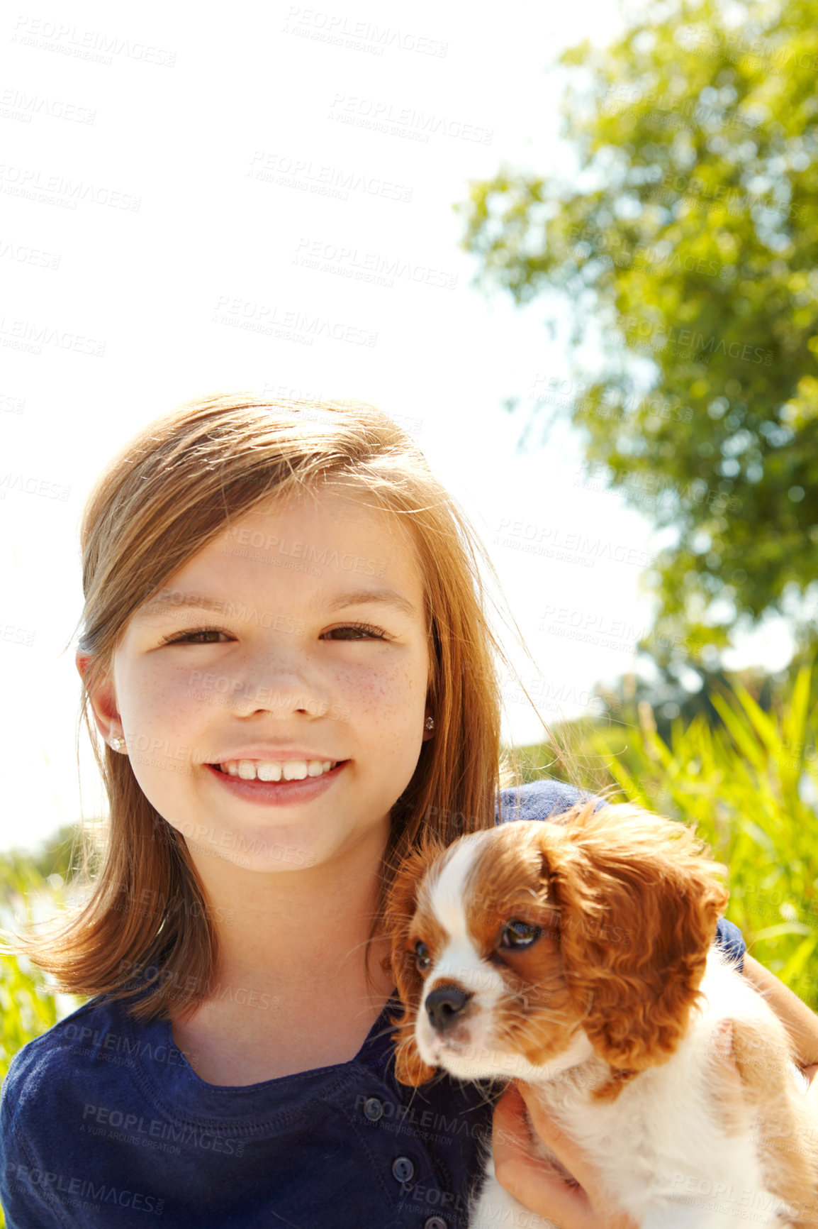 Buy stock photo Portrait of a little girl holding a puppy while standing outside