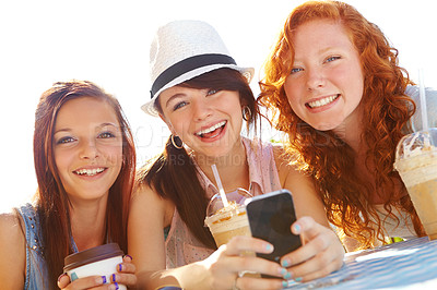 Buy stock photo Three adolescent girls sitting at an outdoor cafe texting on a cellphone