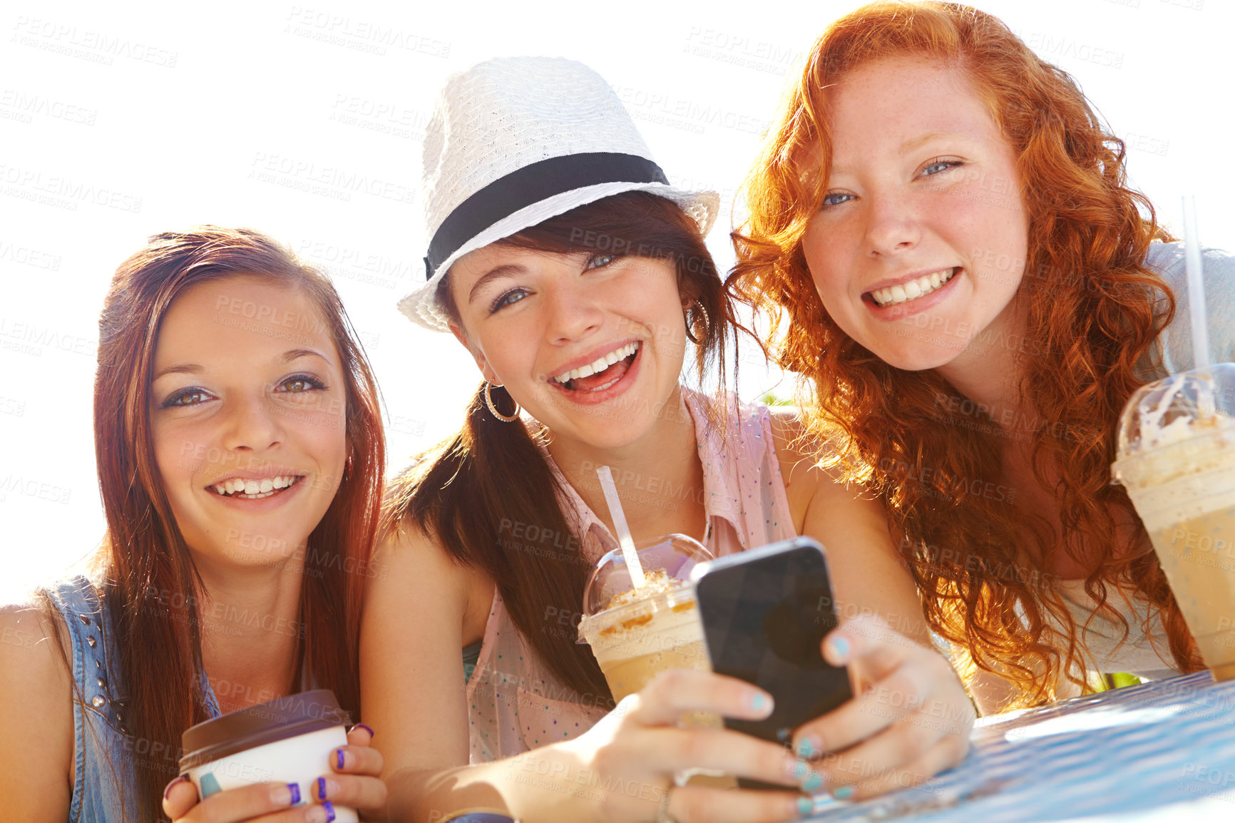 Buy stock photo Phone, cafe and portrait of girl friends drinking ice coffee in park together for break. App, smile and social media with teens at table in nature for bonding or text message communication