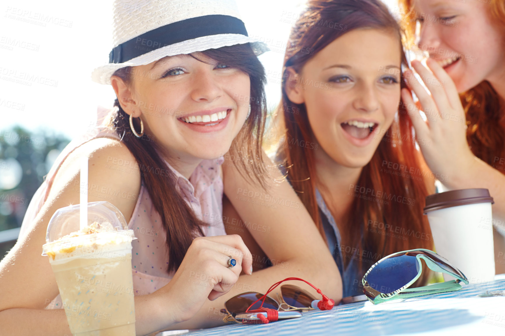 Buy stock photo An adolescent girl smiling at the camera while her friends whisper in the background