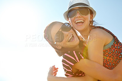 Buy stock photo Two adolescent girls hugging against a bright sunny sky