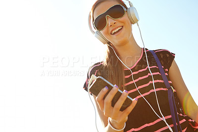 Buy stock photo A happy young teeanage girl listening to music over her headphones