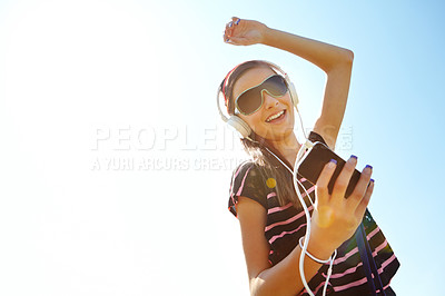 Buy stock photo A happy young teenage girl dancing outside while listening to music on her headphones