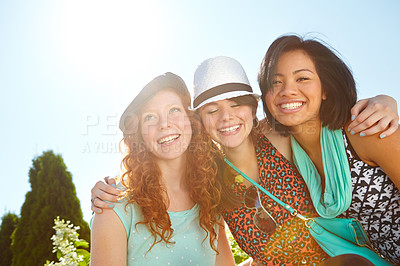 Buy stock photo Three teenage girls smiling happily with their arms around each other