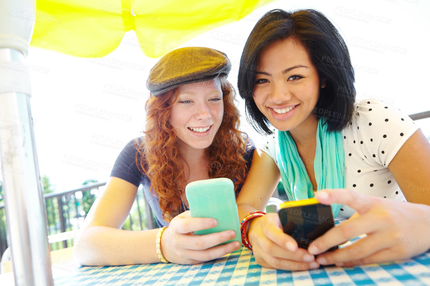 Buy stock photo Two teenage girls sitting outside texting on their cellphones