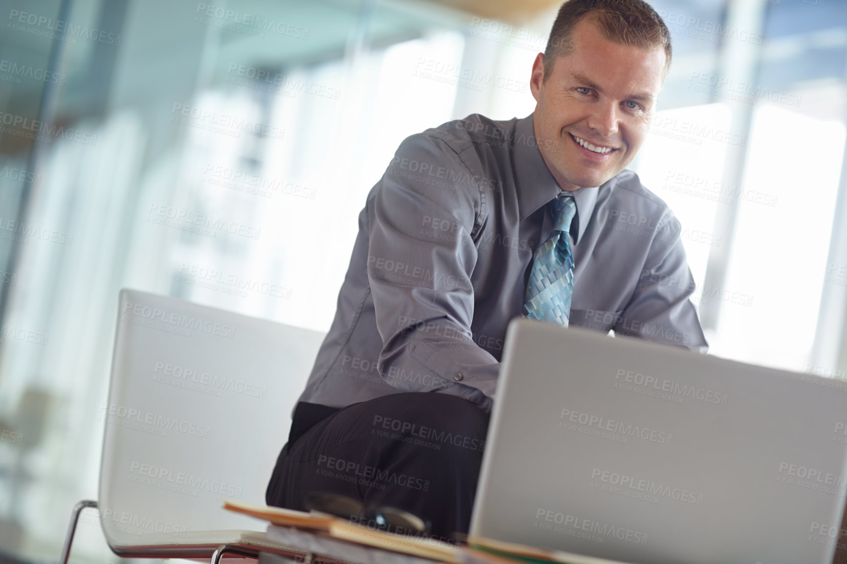 Buy stock photo A handsome young caucasian businessman working on his laptop