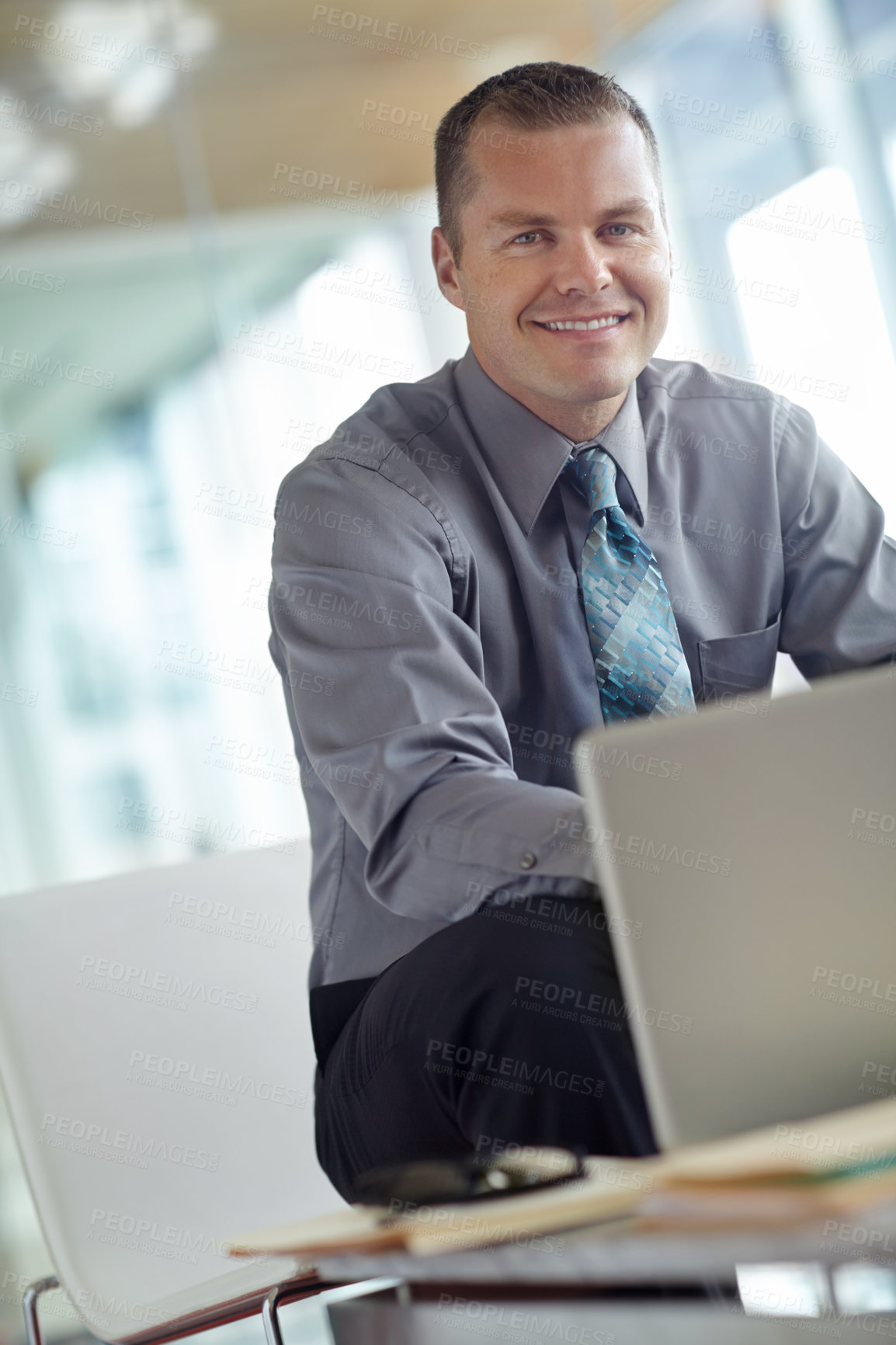 Buy stock photo A handsome young caucasian businessman working on his laptop