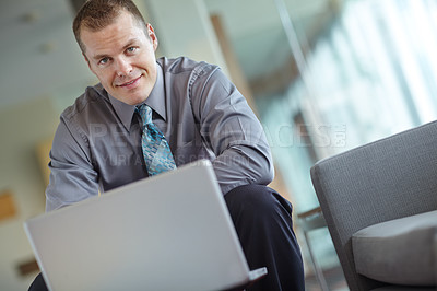 Buy stock photo A handsome young caucasian businessman working on his laptop