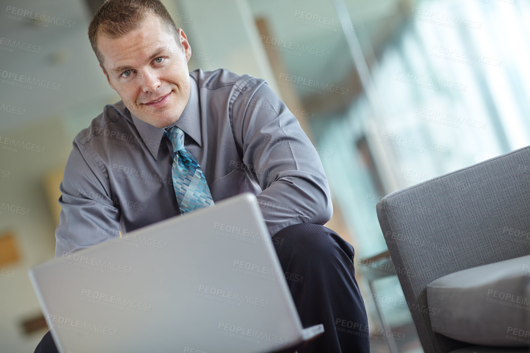 Buy stock photo A handsome young caucasian businessman working on his laptop