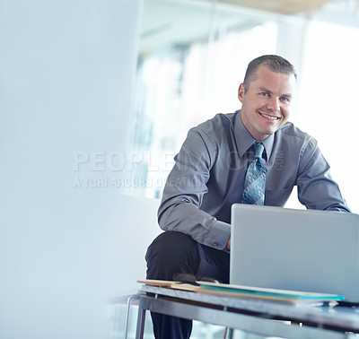 Buy stock photo A handsome young caucasian businessman working on his laptop