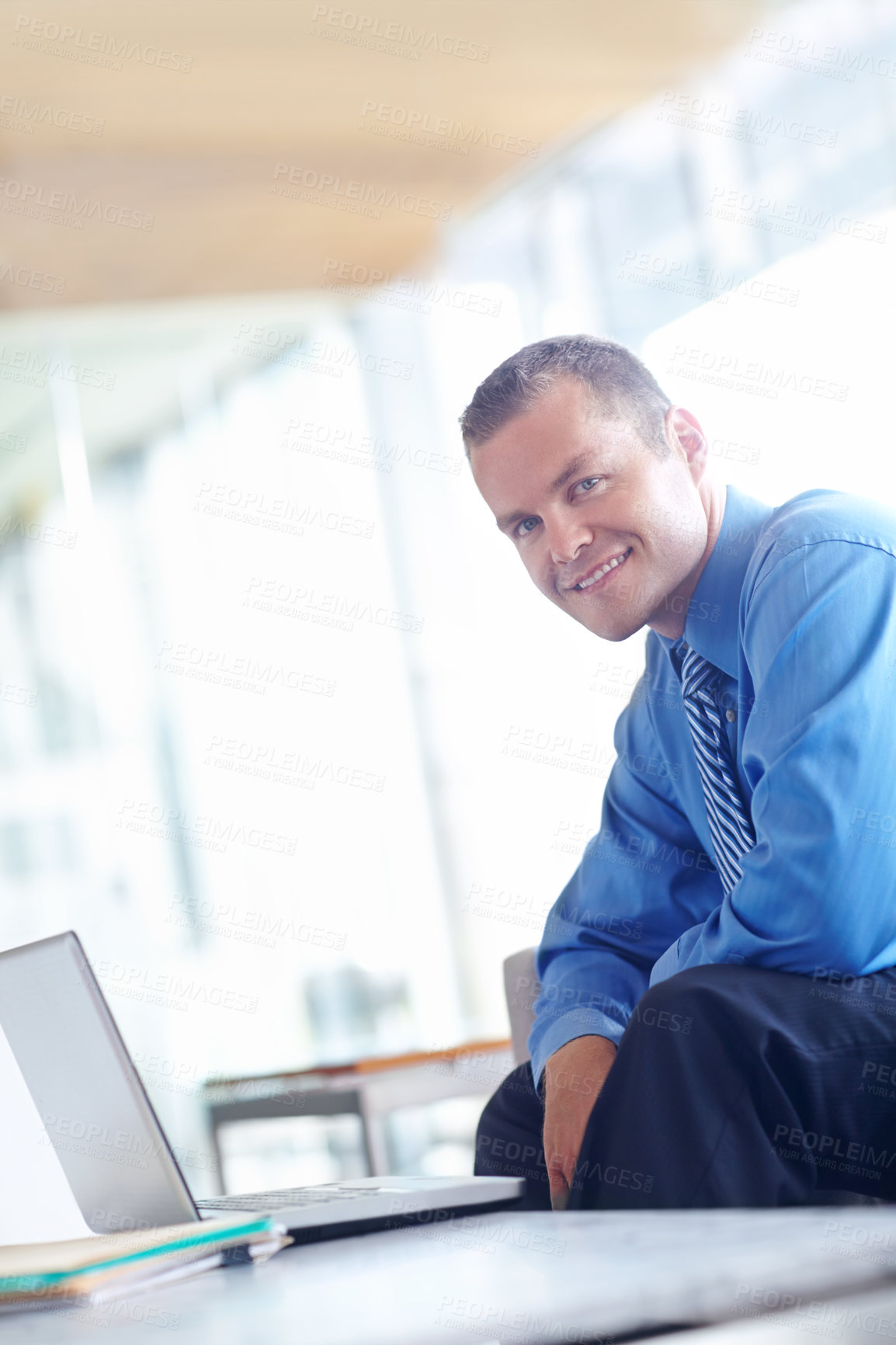 Buy stock photo A handsome young caucasian businessman working on his laptop