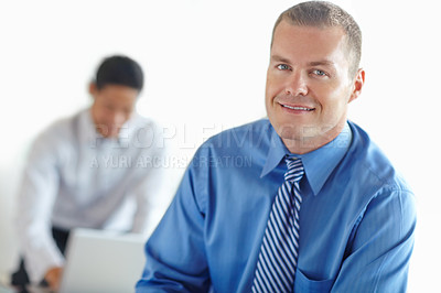 Buy stock photo A handsome caucasian businessman at work with his coworker behind him