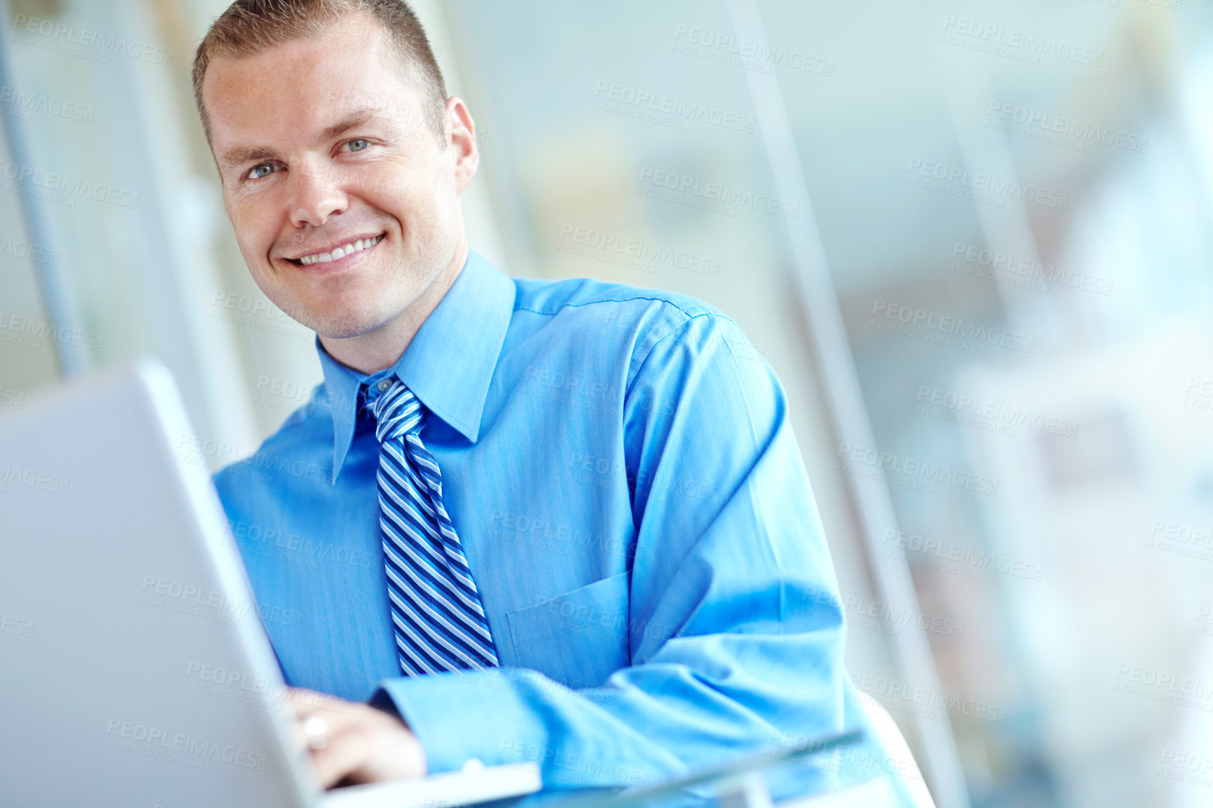 Buy stock photo A handsome young caucasian businessman working on his laptop