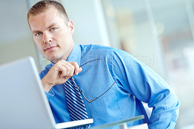 Buy stock photo Thoughtful young caucasian businessman working on his laptop 