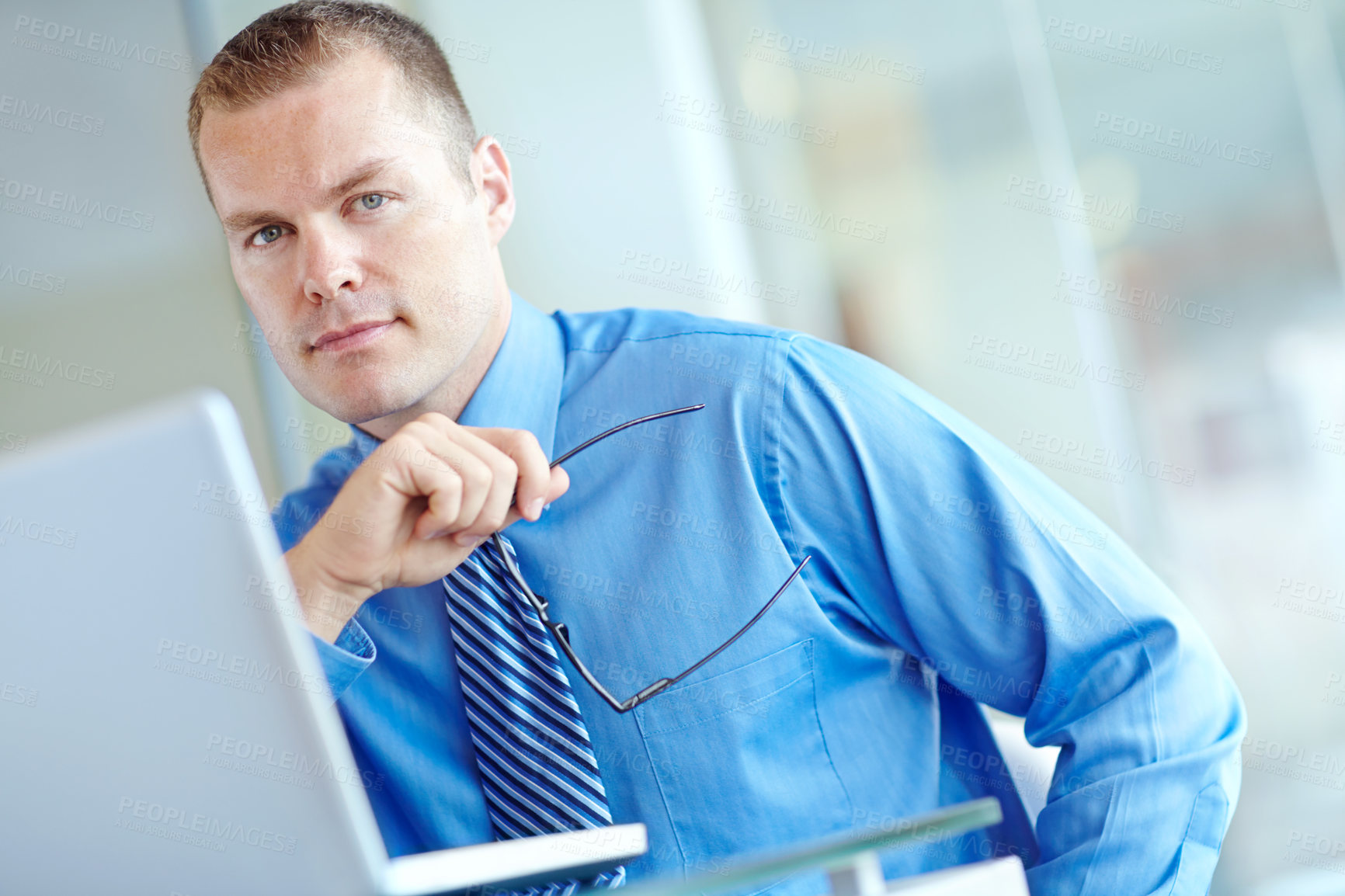 Buy stock photo Thoughtful young caucasian businessman working on his laptop 