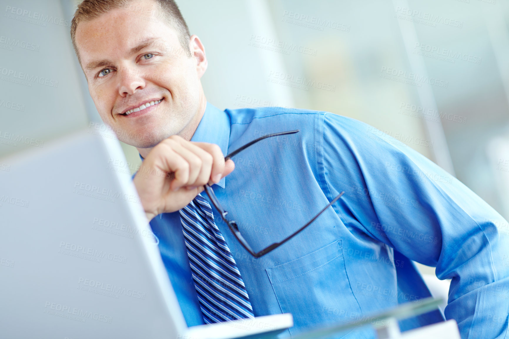 Buy stock photo Thoughtful young caucasian businessman working on his laptop 