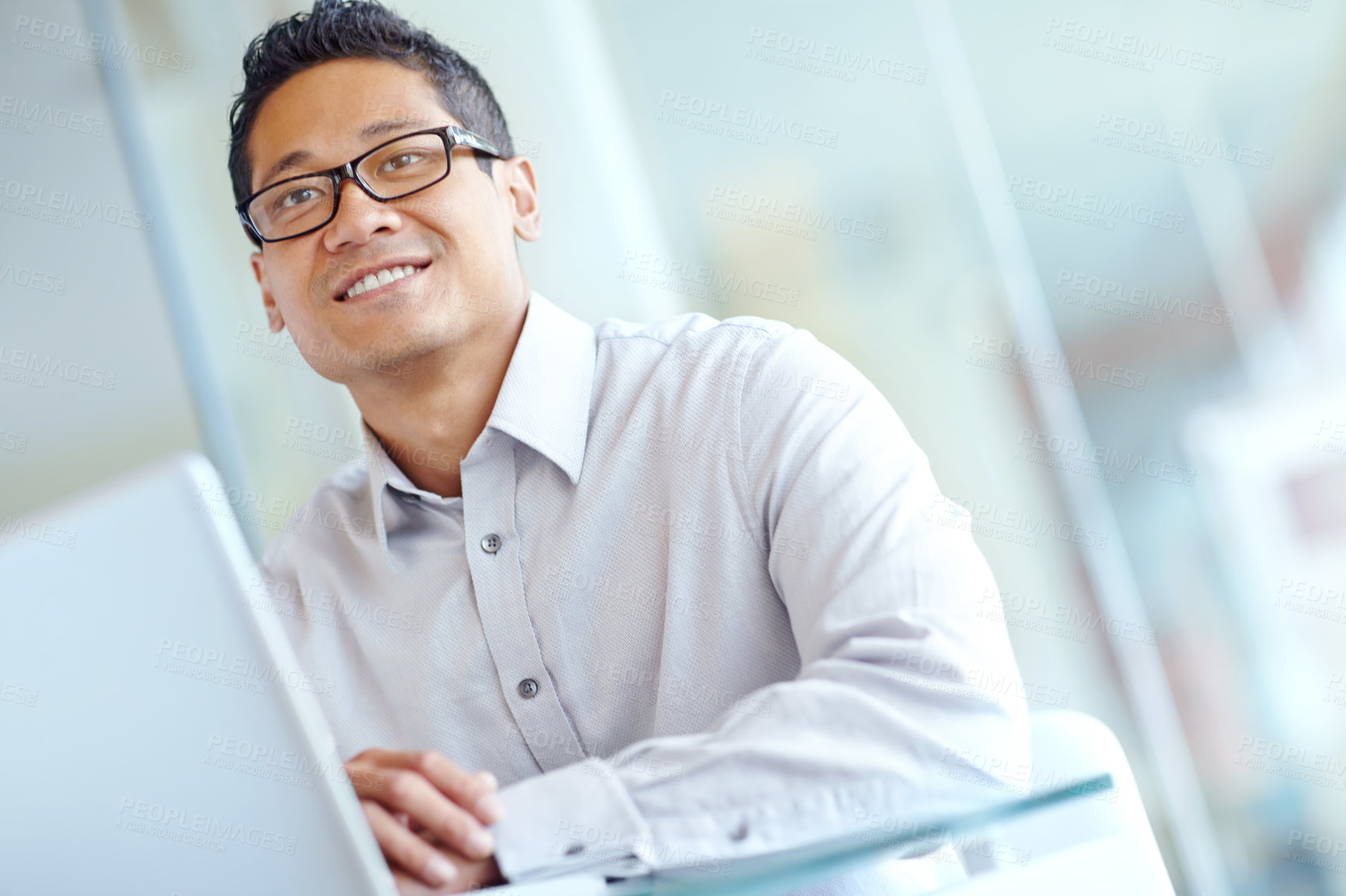 Buy stock photo Thoughtful young asian businessman working on his laptop 