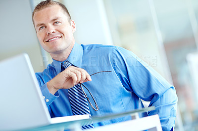 Buy stock photo Thoughtful young caucasian businessman working on his laptop 