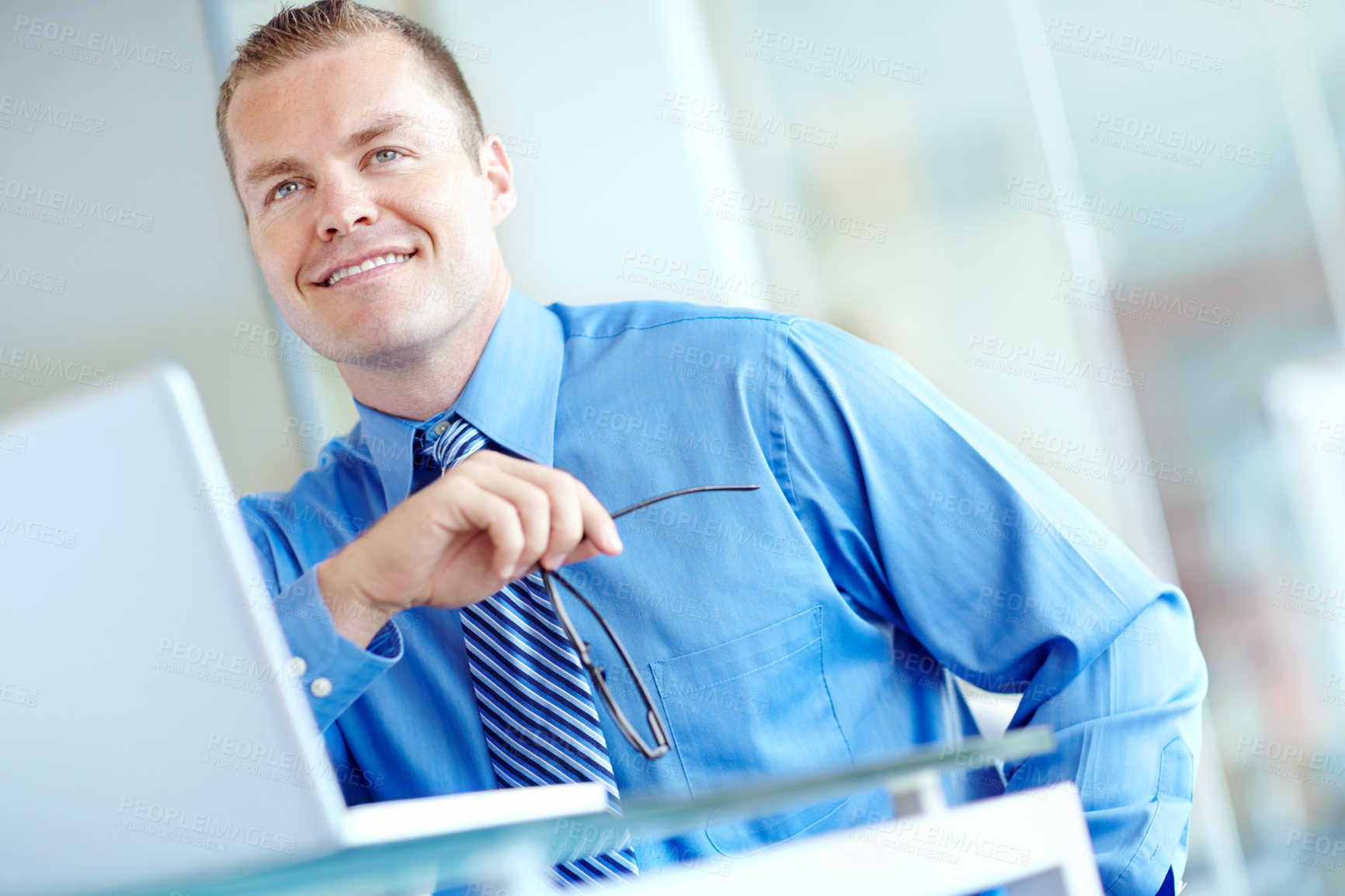 Buy stock photo Thoughtful young caucasian businessman working on his laptop 