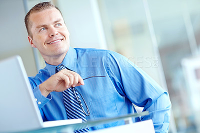 Buy stock photo Thoughtful young caucasian businessman working on his laptop 