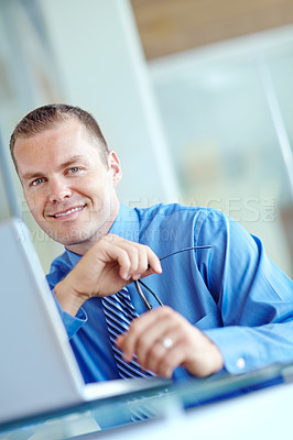 Buy stock photo Thoughtful young caucasian businessman working on his laptop 