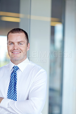 Buy stock photo Smiling caucasian businessman standing at work with his arms folded