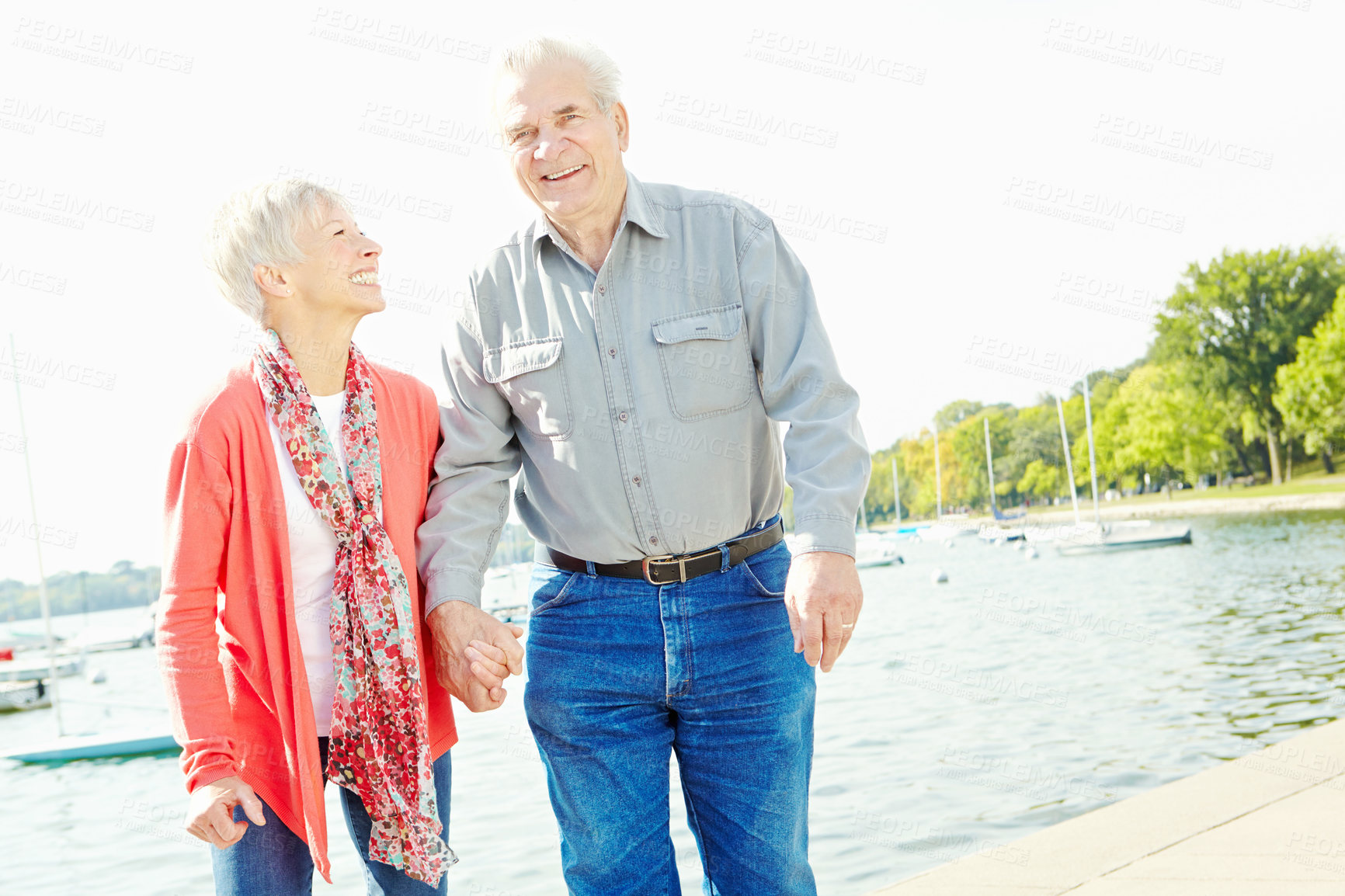 Buy stock photo A senior couple taking a casual stroll along the lakeside