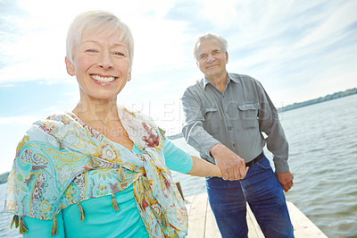 Buy stock photo Senior, happy couple or holding hands with beach for date, old romance or bonding together in nature. Elderly man, woman or lovers with smile by lake, ocean or sea for holiday, weekend or anniversary