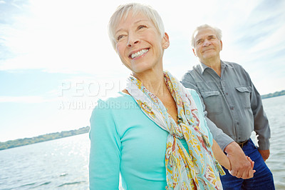 Buy stock photo Senior, happy couple or holding hands with beach for bonding, old romance or date together in nature. Elderly man, woman or lovers with smile by lake, ocean or sea for holiday, weekend or anniversary