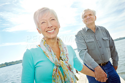 Buy stock photo Senior, happy couple or holding hands with support on beach for bonding, old romance or date together in nature. Elderly man, woman or lovers with smile by ocean or sea for holiday or anniversary