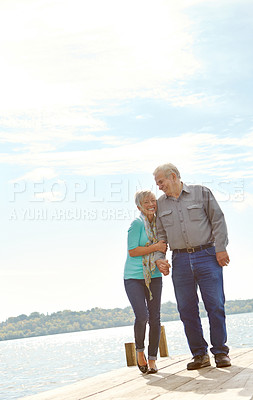 Buy stock photo A senior couple walking along the jetty