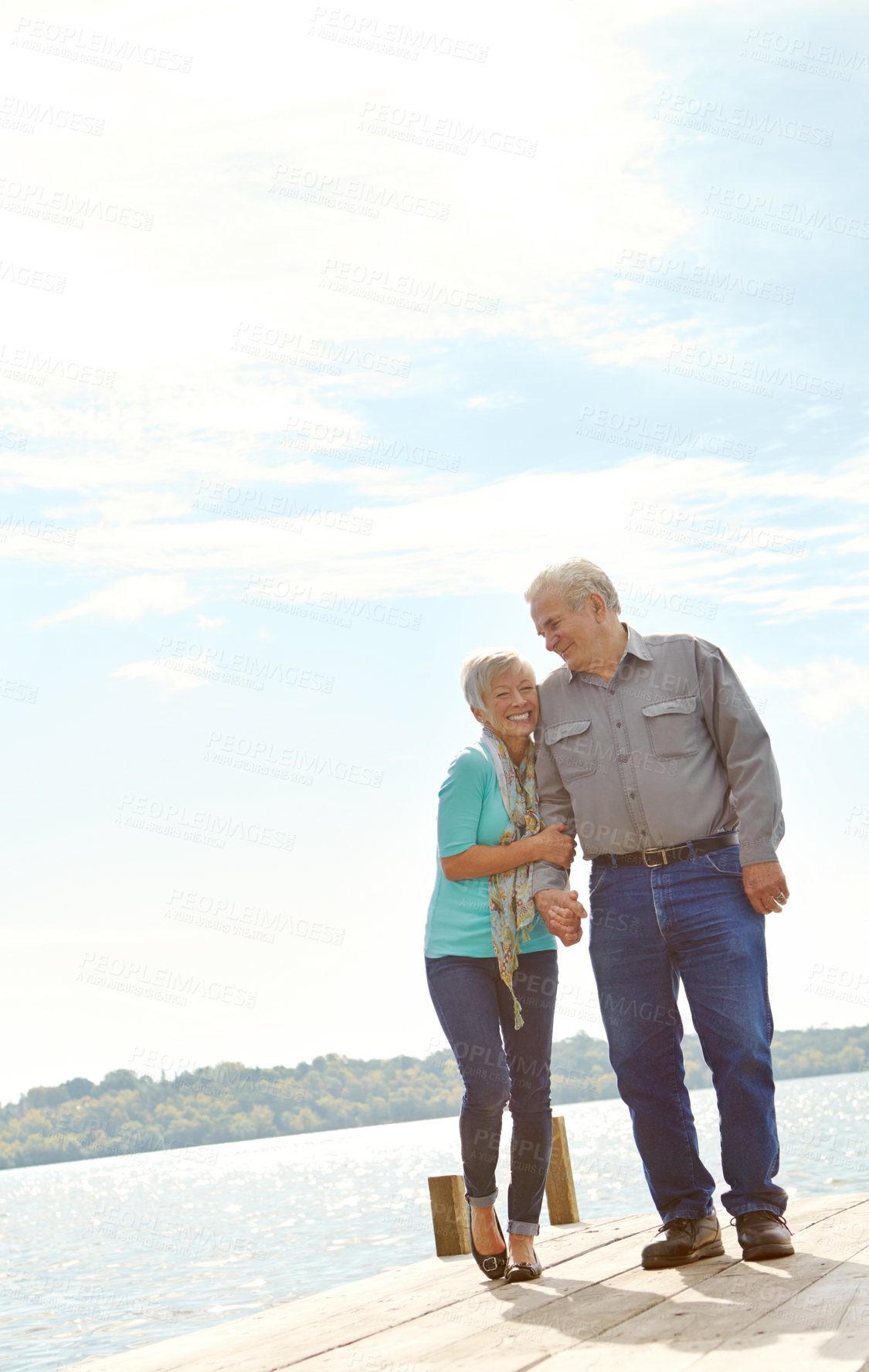 Buy stock photo A senior couple walking along the jetty