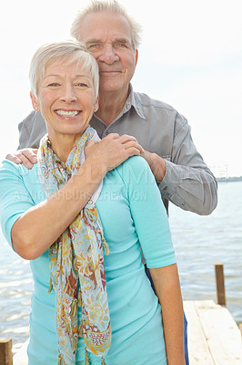 Buy stock photo Image of a senior man standing behind his wife and putting his hands on her shoulders