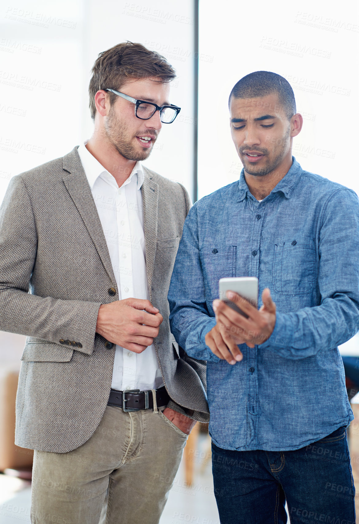 Buy stock photo Men, phone and together in office with discussion for project, research and reading with teamwork. People, smartphone and check notification on app for contact, client or advice at creative agency