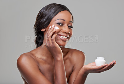 Buy stock photo Woman, skin cream and jar in studio portrait for application, cosmetics and happy by gray background. Girl, model and African person with smile for beauty, skincare and moisturizer for facial glow