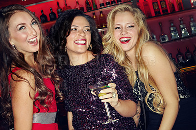 Buy stock photo Three beautiful female friends having fun and cocktails in a night club
