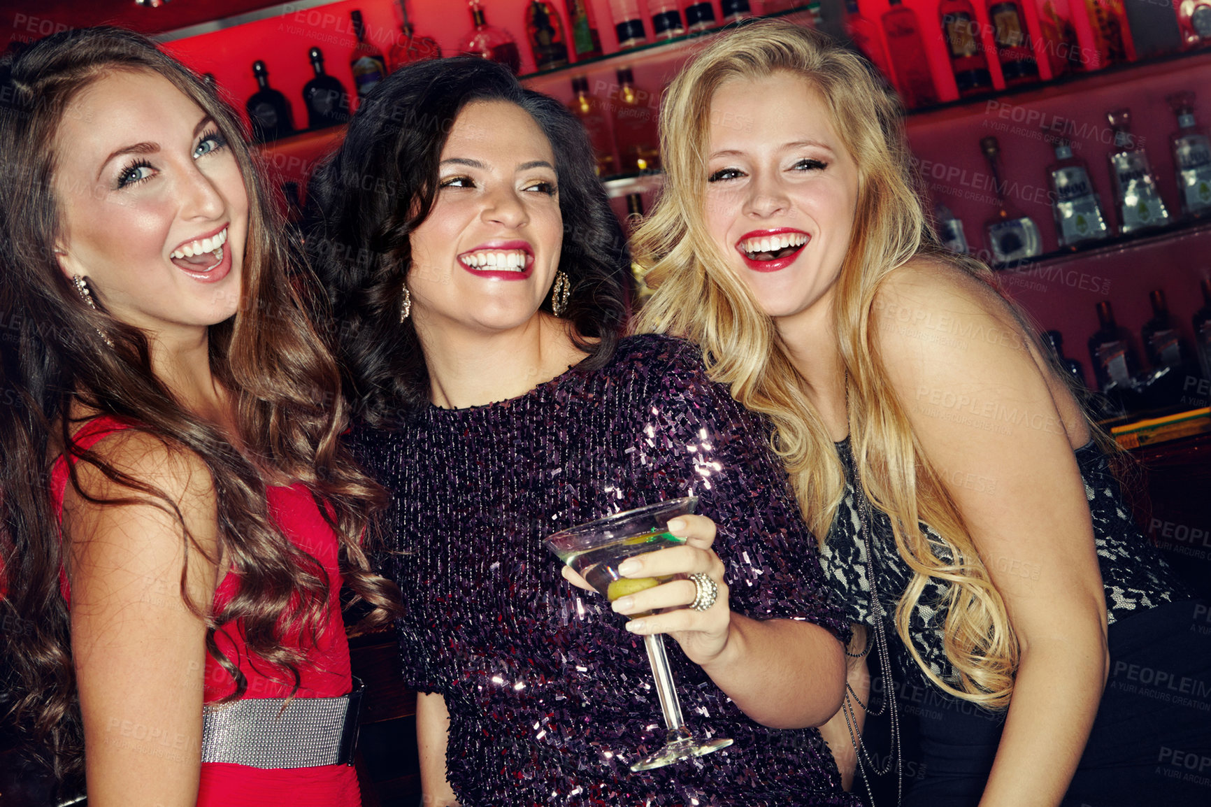 Buy stock photo Three beautiful female friends having fun and cocktails in a night club