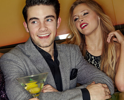 Buy stock photo A young couple enjoying cocktails in a night club