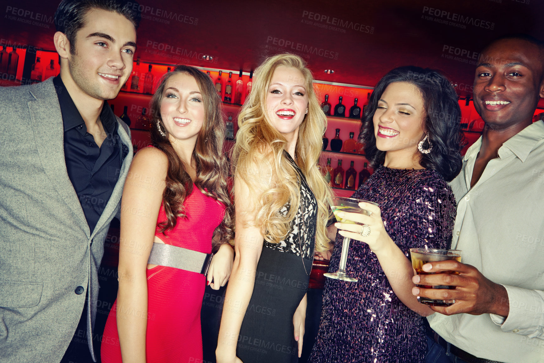 Buy stock photo A group of friends standing together in a night club and enjoying drinks