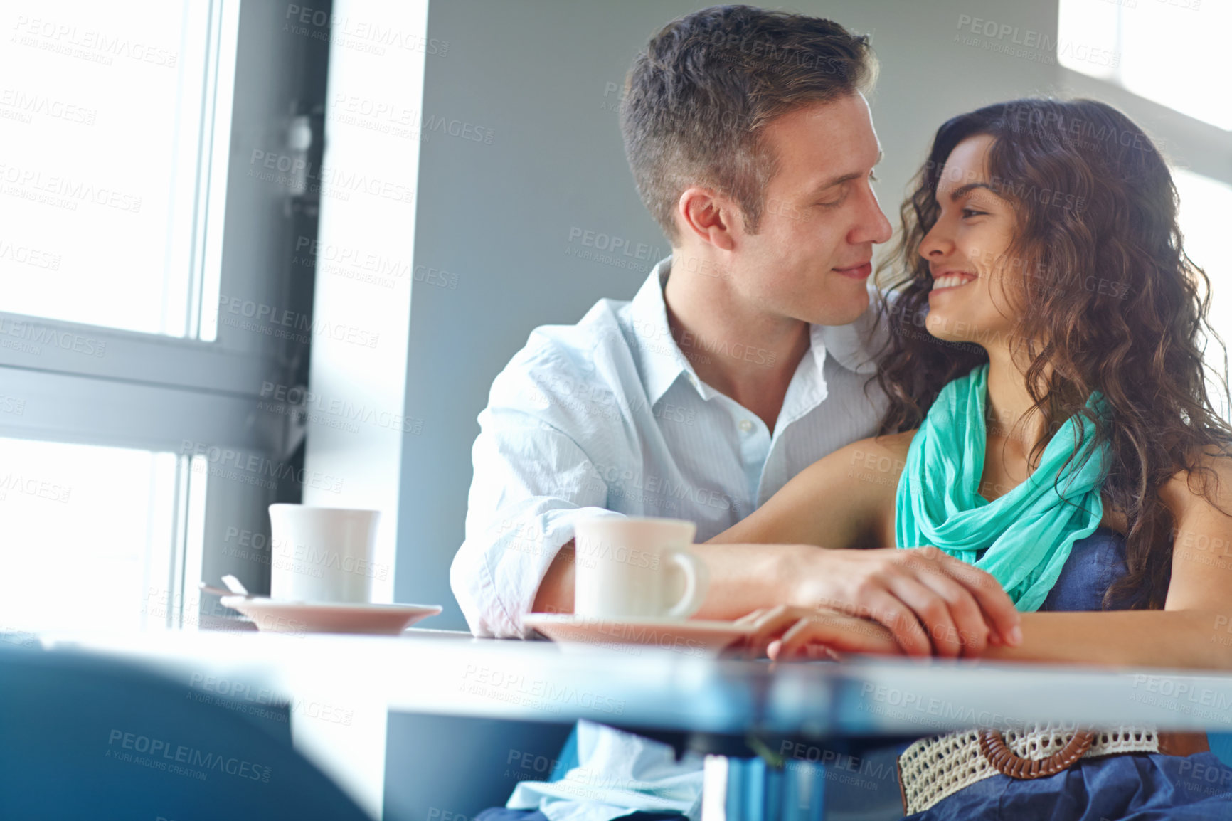 Buy stock photo Happy couple, embrace and love at cafe with talk, bonding or eye contact with memory in morning. Man, woman and support with conversation, drinks or tea with smile, loyalty or trust at coffee shop