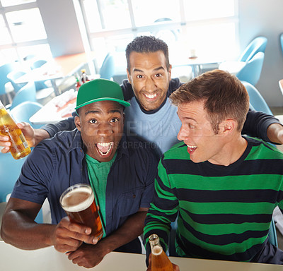 Buy stock photo Top view of a three friends drinking beer and cheering at the bar