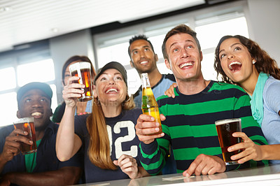 Buy stock photo A group of friends cheering on their favourite team at the bar