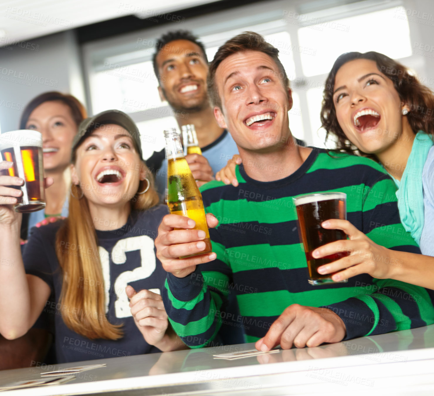 Buy stock photo A group of friends cheering on their favourite team at the bar